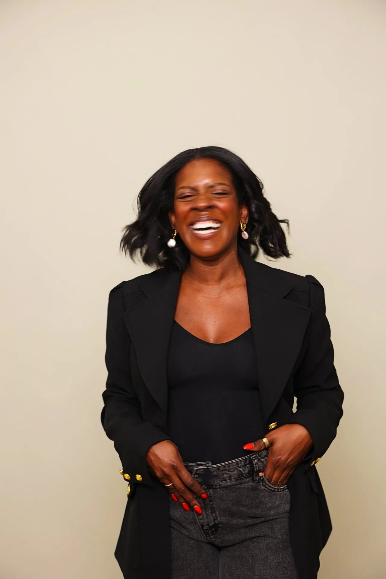 Ashley Rudolph laughing in a black blazer.
