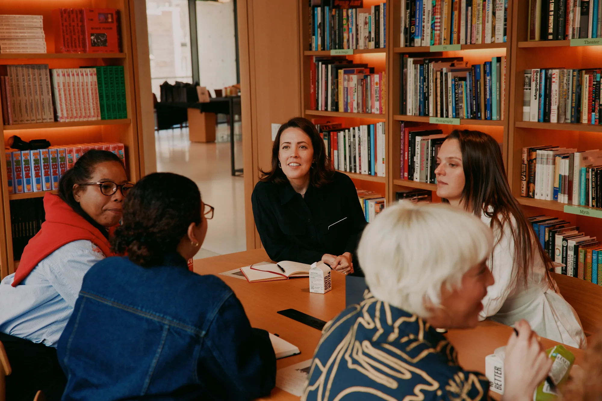 Senior women in conversation around a table at Off The Record.